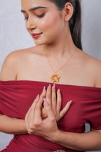 Model looking down, wearing the orange and white beaded star pendant