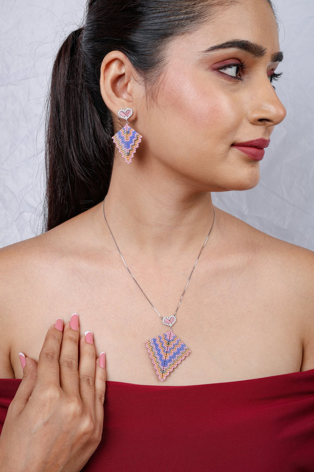 Model wearing pastel beaded kite pendant on silver chain with matching kite drop earrings