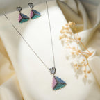 Pastel pyramid necklace set with heart paw-print studs laid on cream fabric