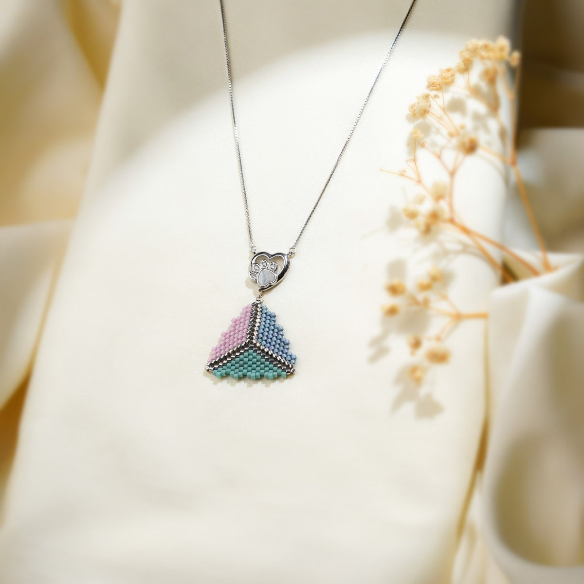 Pink, blue and turquoise triangle pendant under a crystal heart paw-print connector