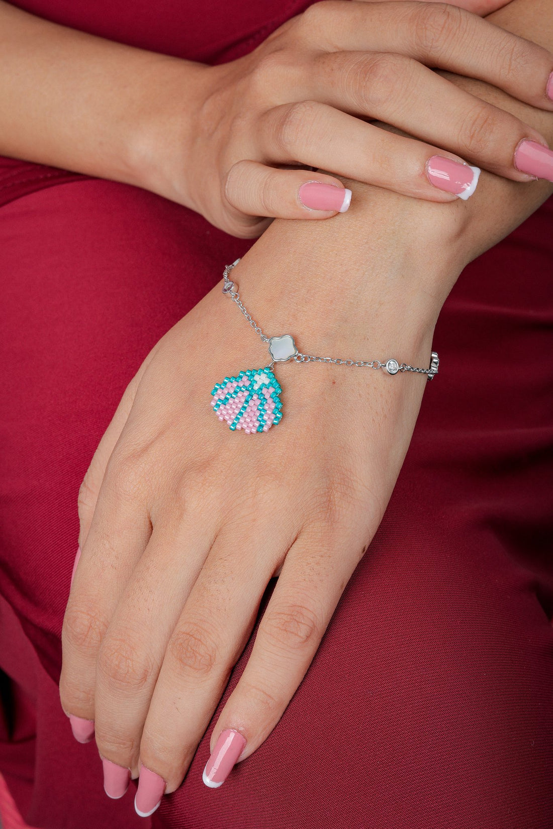 Pastel seashell charm bracelet on a wrist