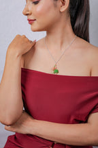 Side view of silver chain necklace with peach and green beaded flower cluster pendant