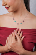 Model wearing silver necklace with five beaded stars in plum and teal