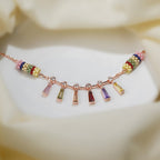 Rose-gold bracelet with six rainbow baguette crystal drops between two striped beaded barrels