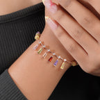 Rose-gold rainbow baguette charm bracelet worn on the wrist