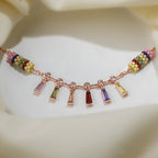 Rose-gold charm bracelet with pink, green, red, purple and yellow baguette drops on cream silk