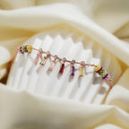 Rainbow baguette crystal bracelet with multicolour beaded barrels draped over a ribbed stand
