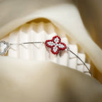 Close-up of red and white beaded clover and crystal-framed white clover on a fluted stand