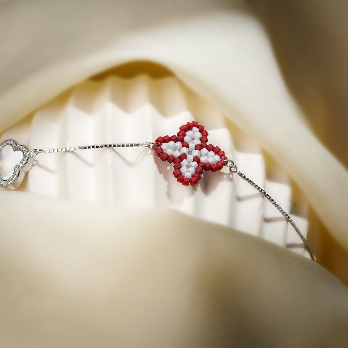 Close-up of red and white beaded clover and crystal-framed white clover on a fluted stand