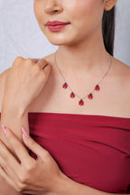 Ladybug charm necklace worn with a red top, model's hand resting on her shoulder