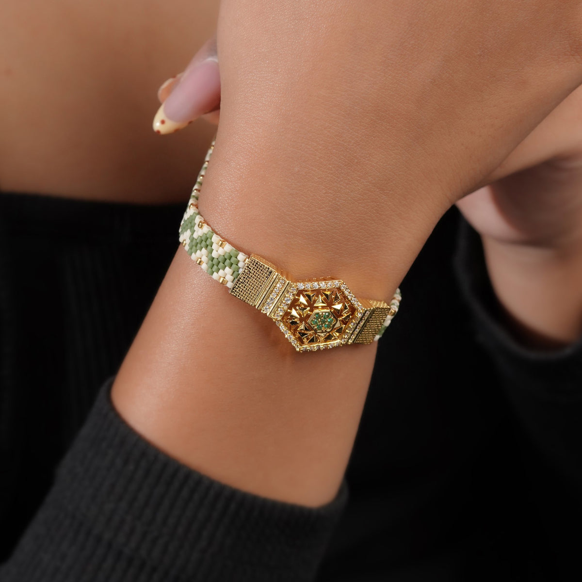 Woven zigzag bead bracelet with gold hexagon centrepiece worn on the wrist