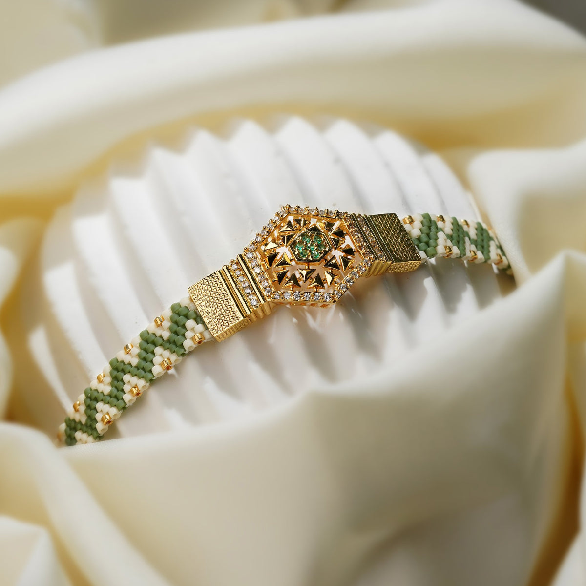 Angled view of zigzag woven bead band leading to textured gold panels and hexagon centrepiece