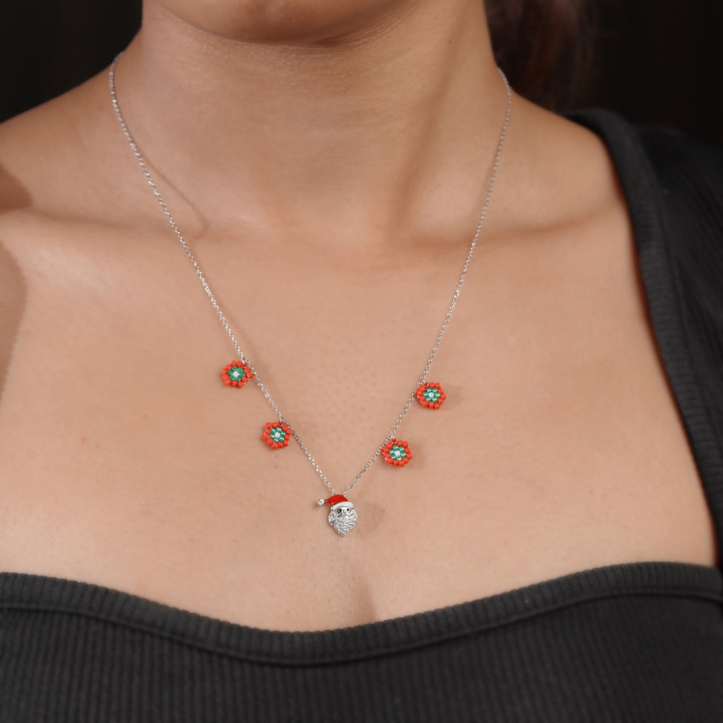 Model wearing silver Christmas necklace with beaded red flowers and Santa pendant