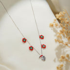 Close-up of red beaded flowers with green centres and sparkling Santa face charm