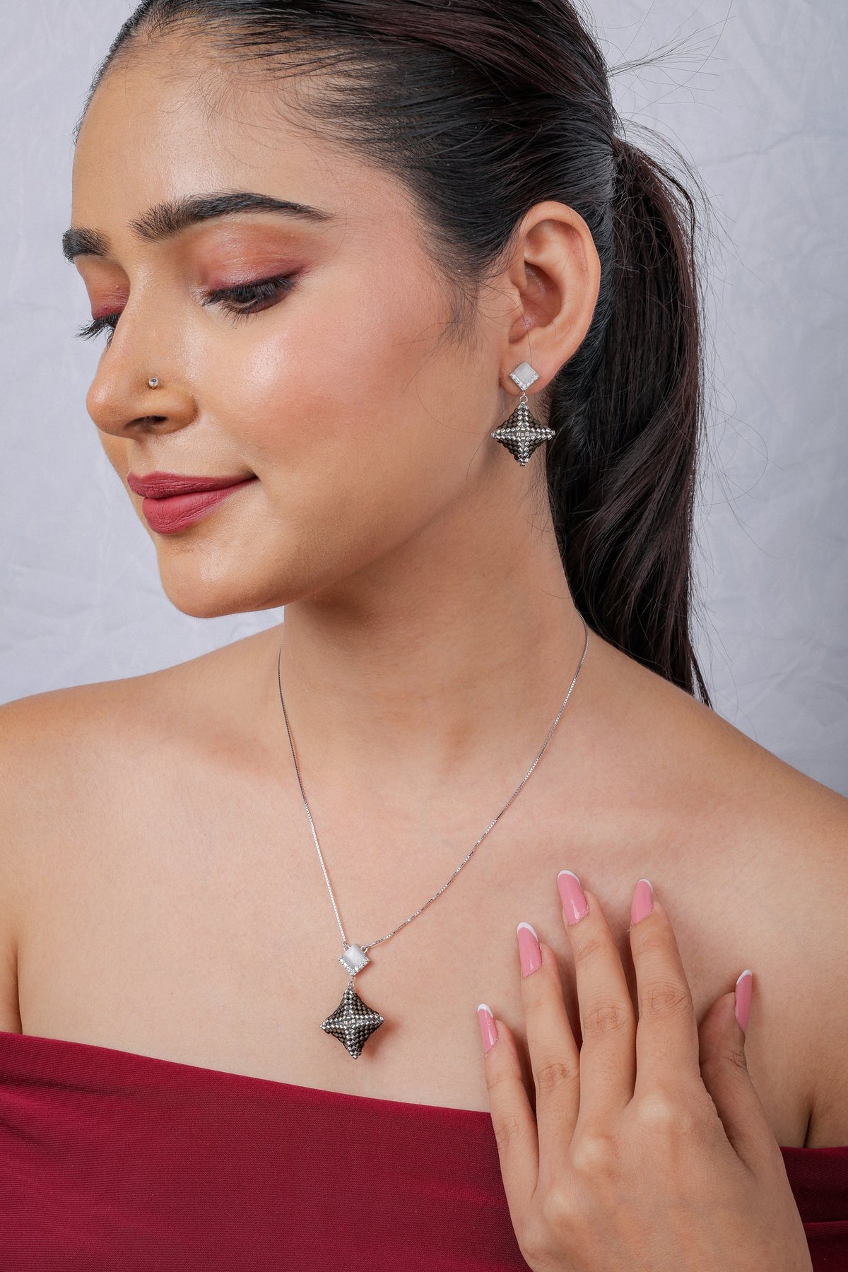 Model wearing silver chain with smoky beaded star pendant and matching star drop earrings