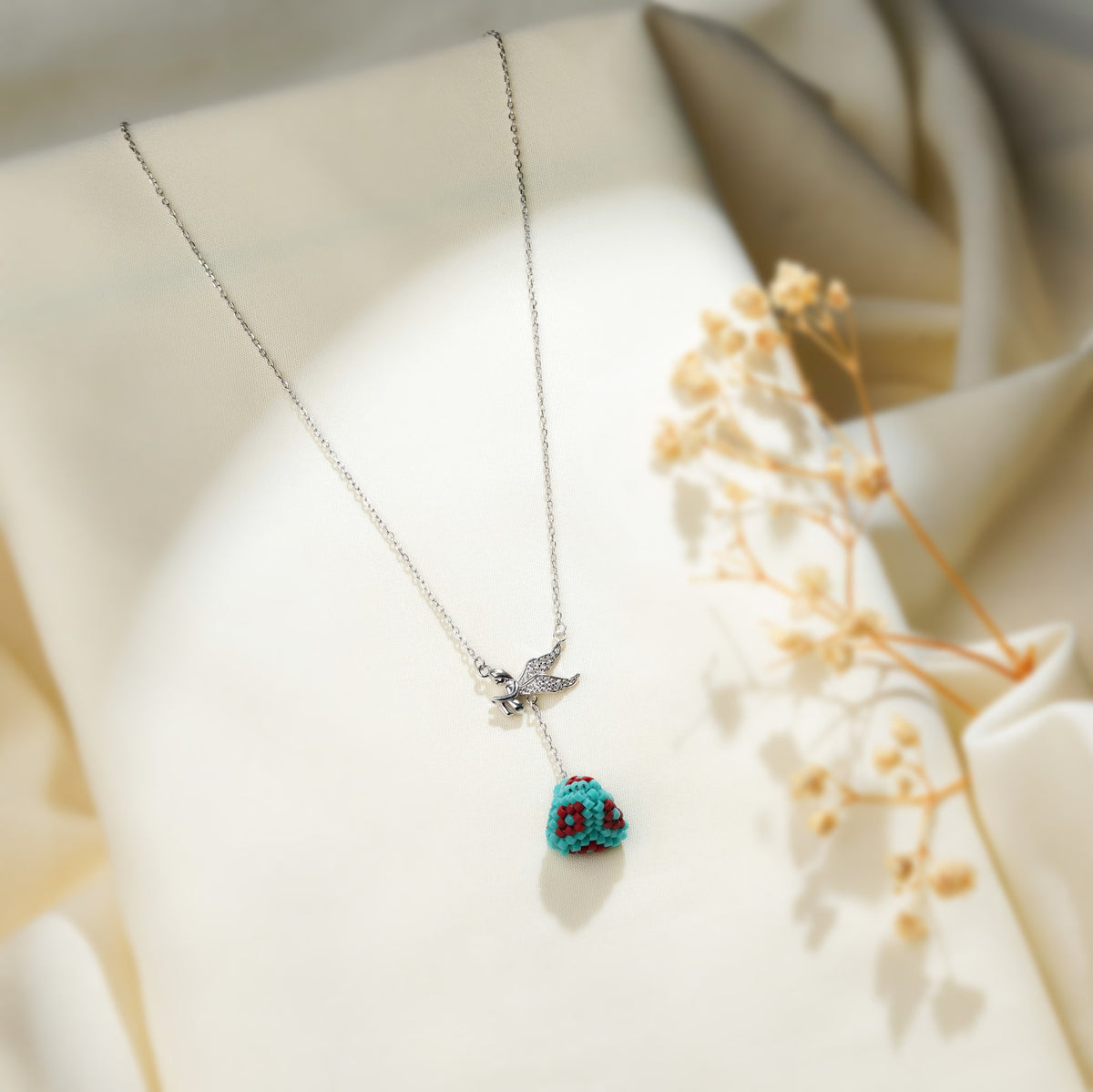 Silver lariat necklace with crystal-winged angel connector and turquoise beaded pyramid drop