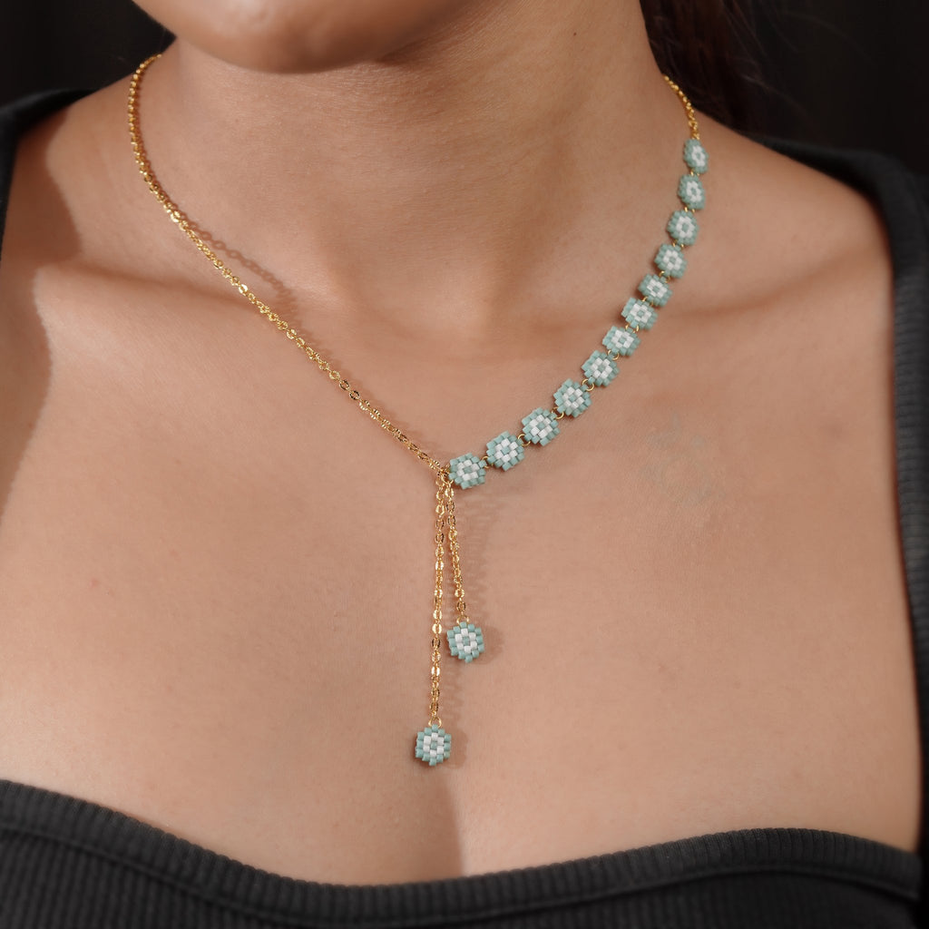 Turquoise daisy lariat worn by a model, the Y-drop falling below the collarbone