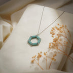 Turquoise hexagon pendant on a silver-tone chain beside dried gypsophila